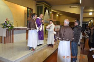 Don Luca prega sui membri della confraternita